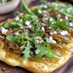 - Flatbread options: You can use store-bought flatbread or make your own. Store-bought is quick and easy. Homemade flatbread can have a special touch. Naan also works great for this recipe. - Onions: I prefer using yellow onions for their sweet flavor. Sweet onions, like Vidalia, also work well. If you want a sharper taste, red onions can add a nice twist. - Olive oil: It helps to cook the onions evenly. The oil adds richness and depth to the dish. Use extra virgin olive oil for the best flavor. - Goat cheese overview: Goat cheese brings a creamy texture. It adds a tangy flavor that pairs well with sweet onions. Crumbled goat cheese melts beautifully on the flatbread. - The importance of arugula: Fresh arugula adds a peppery note. It balances the sweetness of the caramelized onions. Arugula also adds color and freshness to the dish. - Using balsamic glaze for flavor enhancement: Balsamic glaze adds a sweet and tangy kick. Drizzling it on top brings all the flavors together. It gives the flatbread an elegant finish. First, heat olive oil in a large skillet over medium heat. Add the sliced onions, salt, and sugar. Stir well to coat the onions. Cooking onions takes time. Stir them every few minutes. Let them cook for 20 to 25 minutes. You want them to turn golden brown. The sugar helps the onions become sweet. Salt pulls out moisture, making them soft. This step is key for great flavor. While the onions cook, preheat your oven to 400°F (200°C). This ensures even baking. Next, take your flatbread and place it on a baking sheet. After the onions are ready, spread them evenly over the flatbread. Make sure to cover it well. Crumble the goat cheese on top of the onions. This adds a creamy texture and tangy flavor. Now it's time to bake! Place the baking sheet in the preheated oven. Bake for about 10 to 12 minutes. Look for the edges to turn golden brown. The cheese should be soft and slightly melted. This shows that it’s ready. Once done, take it out and let it cool for a minute. You want to let the flavors settle before serving. To get the best caramelization, take your time. Cook the onions for 20-25 minutes. Stir them often to avoid burning. Keep the heat at medium. If it’s too high, the onions will cook too fast. They will not caramelize well. Common mistakes include rushing the cooking time. If you do not let the onions cook long enough, they won’t develop that rich, sweet flavor. Make sure you add the salt and sugar at the start. This helps draw out moisture and enhances sweetness. To add more flavor, consider spices like thyme or rosemary. Both herbs pair well with goat cheese. You may also sprinkle a bit of red pepper flakes for heat. Make your flatbread visually appealing. Use fresh arugula on top for a pop of green. Drizzle balsamic glaze for extra color and flavor. The contrast of colors makes your meal more inviting. {{image_2}} You can change up the cheese on your flatbread. Feta or ricotta can work well. For a sharper taste, try blue cheese. Each cheese brings a unique flavor. Consider extra toppings to add variety. Sautéed mushrooms or bell peppers add great taste. You can also add cooked chicken or prosciutto for protein. Fresh herbs like thyme or basil give a nice touch. If you need a gluten-free option, use gluten-free flatbread. Many stores offer good choices. You can also make your own with almond or coconut flour. For a vegan version, swap goat cheese for a nut-based cheese. Cashew cheese or a store-bought vegan cream cheese works well. Use maple syrup in place of balsamic glaze for a sweet touch. To keep your flatbread fresh, you should store leftovers in the fridge. Wrap it well in plastic wrap or place it in an airtight container. This helps to keep it dry and fresh. If you leave it uncovered, it can become hard or soggy. To avoid sogginess, place a paper towel in the container. This will soak up extra moisture. When you’re ready to enjoy leftovers, reheating is key. For the best texture, use the oven. Preheat your oven to 350°F (175°C). Place the flatbread on a baking sheet. Heat it for about 10 minutes. This will warm it through and keep the edges crispy. You can also use a skillet for reheating. Heat the skillet over medium heat, then place the flatbread in it for about 5 minutes on each side. This method also keeps the flatbread nice and crispy. To get a crispy flatbread, follow these tips: - Use a baking stone or a preheated baking sheet. - Bake at a higher temperature, around 400°F (200°C). - Brush the flatbread lightly with olive oil before baking. - Bake until the edges are golden brown. These steps help create a perfect crunch that everyone loves. The key is heat and a good surface. You can use pre-cooked onions, but there are pros and cons. - Pros: They save time and effort. - Cons: They may lack the deep flavor of caramelized onions. If you choose this shortcut, consider adding a bit of sugar. This can help mimic the sweetness of freshly cooked onions. Pair your flatbread with these tasty side dishes: - A fresh green salad with vinaigrette. - Roasted vegetables for a warm option. - A bowl of soup, like tomato or butternut squash. These sides complement the flatbread well. They add color and flavor to your meal, making it more enjoyable. This blog post covered how to create delicious flatbread. We explored essential ingredients, like different onions and the role of olive oil. You learned how to prepare and assemble flatbread, bake it perfectly, and enhance flavors with toppings. Remember, small changes can lead to big flavors. Try different cheeses or toppings to make your dish unique. You can store and reheat your leftovers with ease. Enjoy your culinary journey and happy cooking!