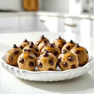 To make these tasty bites, gather the following ingredients: - 1 cup almond flour - 1/2 cup protein powder (vanilla or chocolate) - 1/4 cup maple syrup - 1/4 cup almond butter (or any nut butter) - 1/4 cup chocolate chips (dark or dairy-free) - 1 teaspoon vanilla extract - 1/4 teaspoon sea salt - 2 tablespoons almond milk (or water for consistency) These ingredients blend together to create a delicious, protein-packed snack. - Almond flour: This nut-based flour is high in healthy fats and protein. It adds a nice texture. - Protein powder: A great way to boost the protein content. Choose vanilla or chocolate for added flavor. - Maple syrup: This natural sweetener provides a rich, sweet taste without refined sugars. - Almond butter: Packed with nutrients, it adds creaminess and healthy fats to the bites. - Chocolate chips: These little morsels bring sweetness and a touch of indulgence to each bite. - Vanilla extract: A simple addition that enhances the overall flavor profile. - Sea salt: Just a pinch helps balance the sweetness and brings out the flavors. - Almond milk: This keeps the dough moist and helps achieve the right texture. - Nut allergies: Swap almond flour with oat flour or sunflower seed flour. - Protein powder: Use a plant-based protein powder for a vegan option. - Maple syrup: Honey or agave syrup can work as a sweetener alternative. - Nut butter: Sunflower butter or soy nut butter are great substitutes. - Chocolate chips: You can skip these or use carob chips for a different flavor. These substitutions keep the bites delicious while catering to dietary needs. Making high-protein chocolate chip cookie dough bites is simple and fun. You need about 10 minutes for prep and another 30 minutes for chilling. This recipe makes about 12 to 15 bites. Gather your ingredients first. You will need almond flour, protein powder, maple syrup, almond butter, chocolate chips, vanilla extract, sea salt, and almond milk. 1. Grab a large mixing bowl. Start by adding 1 cup of almond flour and 1/2 cup of protein powder. Mix these two well until they look even. 2. Now, pour in 1/4 cup of maple syrup and 1/4 cup of almond butter. Add 1 teaspoon of vanilla extract and 1/4 teaspoon of sea salt. Stir this mixture until it starts to come together. 3. As you mix, add 2 tablespoons of almond milk, one tablespoon at a time. Keep stirring until the dough is smooth and moldable. 4. Time to add the fun part! Fold in 1/4 cup of chocolate chips. Make sure they spread out well in the dough. 5. Use your hands to make small balls, about 1 inch wide. Place these on a parchment-lined baking tray or plate. 1. Once you shape all the bites, pop the tray in the fridge. Let them chill for at least 30 minutes. This step helps them firm up nicely. 2. After they chill, store your bites in an airtight container. You can keep them in the fridge or freezer for a quick protein boost. Enjoy your tasty treats! To get your cookie dough bites just right, focus on the mixing process. Start with dry ingredients first. Mix the almond flour and protein powder well. This helps avoid clumps later. When you add wet ingredients, do it slowly. This way, you can control the dough's moisture. If the dough feels too dry, add almond milk in small amounts. Aim for a soft yet moldable texture. Watch for a few common issues. First, don't add too much liquid at once. This can make the dough too sticky. Second, ensure your almond flour is fresh. Old flour can affect the taste and texture. Lastly, avoid overmixing the dough after adding chocolate chips. This keeps them intact and prevents a mushy mix. Flavor is key! Try adding a pinch of cinnamon for warmth. You can also use different nut butters for a unique twist. Want a fun look? Serve your bites in small cupcake liners. Sprinkle extra chocolate chips on top for a pop of color. You can even drizzle some melted chocolate over them for extra flair. {{image_2}} You can use many types of protein powder in these bites. I love vanilla or chocolate. But you can also try whey, casein, or plant-based powders. Each type adds its own taste and texture. If you want a nutty flavor, choose pea protein. For a sweet twist, try coconut protein. Just make sure it mixes well with almond flour. You can make your cookie dough bites even more tasty. Add-ins like nuts or dried fruits work great. Chopped walnuts or pecans add crunch. Dried cranberries or cherries give a sweet and tangy flavor. You can also mix in seeds like chia or flax for extra nutrition. Be creative and use what you love! Making these cookie dough bites vegan is simple. Just swap the almond butter for sunflower seed butter. Use maple syrup, which is vegan-friendly. For gluten-free options, stick with almond flour and check your protein powder. Many brands offer gluten-free choices. These easy swaps let everyone enjoy these tasty bites! To keep your high-protein chocolate chip cookie dough bites fresh, store them in an airtight container. This helps prevent them from drying out or absorbing unwanted smells. You can also separate layers with parchment paper. This keeps them from sticking together and makes for easier snacking. In the refrigerator, these bites stay fresh for about one week. If you want to keep them longer, the freezer is your best friend. They can last up to three months in the freezer. Just make sure to thaw them for a few minutes before enjoying. This way, they soften up nicely! Make these cookie dough bites in batches for easy meal prep. After forming the balls, freeze them on a tray first. Once frozen, transfer them to a container for easy access. You can grab a couple for a quick snack or a post-workout treat. They are perfect for busy days! Yes, you can use other flours. Coconut flour works well, but you need less. Start with 1/3 cup. You might need to add more liquid, too. Oat flour is another option. It gives a nice texture and flavor. Just make sure it’s gluten-free if needed. You can tweak the sweetness easily. If you like it sweeter, add more maple syrup. Start with 1 tablespoon at a time. Taste as you go to find what you like. You can also use honey or agave syrup for a different flavor. Absolutely! These bites are perfect for meal prep. You can make a big batch ahead of time. Store them in an airtight container. Keep them in the fridge or freezer for quick snacks. Just thaw them a bit before eating. They’re great for busy days! You learned about making tasty high-protein chocolate chip cookie dough bites. We covered key ingredients, their nutrition, and great substitutions. I shared step-by-step instructions, expert tips for texture, and ways to enhance flavor. You also discovered fun variations and storage tips to keep these bites fresh. These cookie dough bites are perfect for snacks or meal prep. Enjoy making healthy treats that taste great!