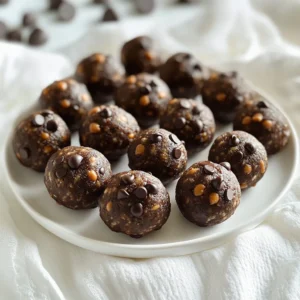 - 1 cup natural peanut butter - 1 cup rolled oats - 1/3 cup honey or maple syrup - 1/4 cup unsweetened cocoa powder - 1/2 cup protein powder (chocolate or vanilla flavor) - 1/4 cup mini dark chocolate chips - 1/4 teaspoon salt - 1 teaspoon vanilla extract To create Chocolate Peanut Butter Protein Balls, gather these simple ingredients. Each item plays a key role in flavor and texture. The natural peanut butter gives a rich taste and healthy fats. Rolled oats add fiber, making these snacks filling. Honey or maple syrup provides sweetness and binds the mixture. Unsweetened cocoa powder adds that deep chocolate flavor we love. Protein powder boosts the nutritional value. You can choose either chocolate or vanilla. Mini dark chocolate chips add a fun crunch and extra sweetness. A pinch of salt balances the flavors, while vanilla extract enhances the overall taste. - Calories per ball: About 100 calories - Protein content: Approximately 5 grams per ball - Macro breakdown: - Fat: 6 grams - Carbohydrates: 9 grams - Fiber: 1 gram These protein balls are not just tasty; they also provide a good amount of protein. Each ball has about 100 calories, which makes them a great snack option. With 5 grams of protein, they help you stay full and energized. The healthy fats from peanut butter support a balanced diet. This snack is perfect for an afternoon boost or a post-workout treat. 1. Start by grabbing a large mixing bowl. 2. Combine 1 cup of natural peanut butter, 1/3 cup of honey (or maple syrup), and 1 teaspoon of vanilla extract. Mix until smooth and creamy. 3. In another bowl, mix 1 cup of rolled oats, 1/4 cup of unsweetened cocoa powder, 1/2 cup of protein powder, 1/4 teaspoon of salt, and 1/4 cup of mini dark chocolate chips. 4. Add the dry mixture to the wet ingredients. Stir until everything comes together. You want a thick dough. 5. If the mixture feels sticky, wait a few minutes. This lets the oats soak up some liquid. You can add more protein powder if needed. 1. Take some dough and use your hands to shape it into small balls, about 1 inch wide. 2. To keep them uniform, use a small cookie scoop. This helps make each ball the same size. 3. Place the balls on a baking sheet lined with parchment paper. This keeps them from sticking. 1. Put the baking sheet in the fridge for at least 30 minutes. This helps the balls firm up. 2. Once chilled, you can enjoy them right away. They make a great snack! 3. Store any leftovers in an airtight container in the fridge. They stay fresh and tasty for about a week. To get the right texture for your protein balls, adjust the consistency as needed. If the mix feels too sticky, let it sit for a few minutes. This allows the oats to soak up some moisture. You can also add a bit more protein powder to thicken it up. Aim for a dough that holds together but isn’t too crumbly. It should be easy to shape into balls without sticking to your hands. You can boost the flavor with some optional ingredients. Consider adding a pinch of cinnamon or a scoop of chia seeds for extra nutrients. If you like a different taste, try using almond butter instead of peanut butter. You can also swap honey for maple syrup if you prefer a vegan option. Feel free to experiment with different protein powder flavors, like vanilla or even berry. These protein balls are great for any time of day. They make an awesome snack before a workout or a quick breakfast on the go. Pair them with a smoothie or yogurt for added protein. You can even enjoy them as a sweet treat after a meal. They’re perfect for kids too, making them a fun and healthy snack option. Store them in an airtight container in the fridge to keep them fresh. {{image_2}} You can switch things up with different nut butters. Try almond or cashew butter for a new twist. Each nut butter brings its own taste and texture. You can also use different protein powder flavors. Chocolate is great, but vanilla or even cookies and cream can work well too. The choice is yours! If you follow a vegan diet, you can easily make these protein balls vegan. Use agave syrup instead of honey. You can also create a nut-free version. Just swap peanut butter for sunflower seed butter. This keeps the protein balls safe for those with nut allergies. Think about adding seasonal flavors. For the holidays, mix in spices like cinnamon or nutmeg. They add warmth and joy to your snacks. In the summer, you can make fruity protein balls. Add a mix of dried fruits like cranberries or apricots for a burst of flavor. Each season brings new ideas! Store your chocolate peanut butter protein balls in an airtight container. This keeps them fresh. You can use glass or plastic containers. I prefer glass for easy cleaning. Refrigeration is the best option for short-term storage. They stay good for a week in the fridge. If you want to keep them longer, freezing is great. Just make sure to wrap them well or use a freezer-safe container. How long do protein balls last? They last about a week in the fridge. If frozen, they can last for up to three months. Look for signs of spoilage. If they smell off or look dry, toss them out. Also, if they feel sticky or mushy, it's best to discard them. To restore texture, let frozen protein balls thaw in the fridge overnight. This keeps them from getting too soft. For quick thawing, you can leave them at room temperature for about 30 minutes. Avoid using a microwave, as it can change their texture. Enjoy your snack after they are thawed! Yes, you can swap honey or maple syrup for other sweeteners. Agave syrup works well. Stevia is a great low-calorie choice. Coconut sugar adds a nice caramel flavor, too. Just keep in mind that sweetness levels can differ. Always taste as you go to find your perfect balance. Absolutely! These protein balls are perfect for meal prep. You can make a big batch in about 15 minutes. Once you form the balls, store them in an airtight container. Keep them in the fridge for quick snacks all week. They also freeze well for longer storage. Just thaw before you enjoy! To make these protein balls gluten-free, choose certified gluten-free oats. Most brands offer this option now. Check the protein powder for gluten content as well. Many are gluten-free, but it’s best to double-check. With these simple swaps, you can enjoy these tasty snacks without worry! In this article, we explored how to make tasty protein balls. We discussed key ingredients, nutritional facts, and easy steps for preparation. You learned tips for texture, flavor, and serving ideas. We also shared variations and storage tips to keep your protein balls fresh. These simple snacks are great for fuel or dessert. Try making them to fit your taste and needs. Enjoy the health benefits while treating your taste buds!