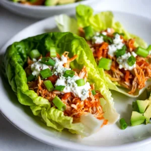 - 1 lb boneless, skinless chicken breasts - 1/2 cup buffalo sauce - 1/2 cup cream cheese - 1/4 cup Greek yogurt - 1/4 cup celery, finely chopped - 1/4 cup green onions, chopped - Salt and pepper - 1 head of romaine or butter lettuce - Crumbled blue cheese - Avocado slices - Additional celery for crunch The main ingredients for Buffalo Chicken Lettuce Wraps focus on flavor and texture. You need chicken, buffalo sauce, cream cheese, and Greek yogurt. The chicken gives a great base. The buffalo sauce adds heat. Cream cheese and Greek yogurt bring creaminess. The additional ingredients add crunch and freshness. Celery and green onions brighten the dish. Salt and pepper enhance all the flavors. The lettuce wraps hold everything together. Romaine or butter lettuce works best here. You can add optional toppings to make it even better. Crumbled blue cheese gives a tangy bite. Avocado slices add creaminess and healthy fats. Extra celery provides even more crunch. These choices let you customize your wraps to your liking. {{ingredient_image_1}} To start, cook the chicken breast until it&rsquo;s fully done. You can boil, bake, or grill it. After the chicken cools, shred it using your hands or two forks. Next, take a mixing bowl and add your shredded chicken. Pour in the buffalo sauce. Stir well to coat all the chicken with the sauce. This step gives the chicken its signature flavor. Now, grab another bowl. Add the softened cream cheese and Greek yogurt. Blend them together until the mix is smooth and creamy. This creamy base will balance the heat of the buffalo sauce. Season the mixture with salt and pepper. Taste it to ensure it has just the right flavor. If you like, you can add some fresh herbs for extra taste. It&rsquo;s time to assemble your wraps! First, prepare the lettuce leaves. I prefer romaine or butter lettuce because they are sturdy and hold well. Take a lettuce leaf and spread a dollop of the cream cheese mixture in the center. Make sure to leave some space at the edges for folding. On top of the cream cheese, add a generous portion of the buffalo chicken. Feel free to pile it on for more flavor! For extra crunch, sprinkle some finely chopped celery and green onions. If you like blue cheese or avocado, add that too. Finally, fold the lettuce leaf around the fillings. Enjoy your tasty buffalo chicken wrap! You can easily adjust the spice level in your Buffalo Chicken Lettuce Wraps. Start by changing the amount of buffalo sauce you use. If you like it hotter, add more sauce. For a milder wrap, use less sauce. You can also try different hot sauces. Each sauce has its own flavor and heat. Experiment with your favorites. This lets you create a wrap just for you. Getting a smooth cream cheese mixture is key. Start with softened cream cheese. Mix it with Greek yogurt. Blend until it is creamy and smooth. This helps the wrap taste great. If you want a change, you can use sour cream instead of Greek yogurt. This will give a tangy twist to your wraps. Adding crunch to your wraps makes them more fun to eat. Try adding chopped celery or bell peppers. You can also use crispy carrots for extra texture. For a flavorful vegetarian option, swap out the chicken. Use roasted chickpeas or black beans instead. This keeps your wraps tasty and healthy! Pro Tips Adjust the Spice Level: Feel free to modify the amount of buffalo sauce based on your heat preference. Start with less and add more to taste! Make Ahead: Prepare the buffalo chicken mixture and cream cheese spread in advance. Store them in the fridge for quick assembly when you're ready to eat. Experiment with Greens: Try using different types of lettuce or even collard greens for a unique wrap experience! Serving Suggestions: Pair these wraps with a side of carrot sticks or celery for a complete snack or light meal. {{image_2}} To make these wraps even easier, try rotisserie chicken. It saves time and tastes great. Just shred the chicken and mix it with the buffalo sauce. This shortcut will cut your prep time in half. For a lighter touch, look for low-fat cream cheese. It gives you the same creamy taste but with fewer calories. You can also use Greek yogurt for a healthy twist. It adds protein and keeps the dip smooth. Don't be afraid to switch up the flavors. Instead of buffalo sauce, try BBQ or ranch sauce. Each sauce brings a new taste to your wraps. You can also mix in herbs and spices like garlic powder or smoked paprika. This makes your wraps pop with flavor. These wraps are great on their own, but you can pair them with dips too. A side of ranch or blue cheese dressing works well. You can also add them to salads or grain bowls for a filling meal. Just chop the wraps and mix them in. It&rsquo;s a fun way to enjoy this dish in different ways. To keep your buffalo chicken lettuce wraps fresh, store leftovers correctly. Place the chicken and cream cheese mixture in separate containers. This helps the lettuce stay crisp. Use airtight containers or resealable bags to keep out air and moisture. Label the containers with the date. Enjoy the wraps within three days for the best taste. When reheating, use the microwave or stovetop. Heat the chicken mixture until it's warm. Avoid reheating the lettuce. To keep the lettuce from getting soggy, add fresh leaves when you're ready to eat. This way, your wraps stay crunchy and tasty. You can freeze the buffalo chicken mixture for later. Place it in an airtight container or freezer bag. Be sure to remove as much air as possible. It can last up to three months in the freezer. When ready to use, thaw it in the fridge overnight. Reheat it gently on the stove or in the microwave. Enjoy your delicious buffalo chicken again! Yes, you can prepare these wraps ahead of time. To store, keep the chicken mixture and the cream cheese mix in separate containers. Refrigerate them for up to three days. Before serving, fill the lettuce just before eating. This helps keep the lettuce crisp and fresh. If you want alternatives, consider using these options: - Cabbage leaves for a sturdier wrap - Collard greens for a heartier bite - Sliced bell peppers for a crunchy twist These options work well for gluten-free or low-carb diets. To turn up the heat, try these ideas: - Add more buffalo sauce to the chicken mix. - Include sliced jalape&ntilde;os for an extra kick. - Use a hotter sauce like sriracha or habanero sauce. Adjust to your taste for the perfect level of spice. These Buffalo Chicken Lettuce Wraps are easy to make and customize. You learned about the main ingredients, step-by-step instructions, and tips for storage. You can adjust flavors and spice levels to fit your tastes. With simple swaps, you can create healthy versions or try different sauces. Enjoy these wraps as fun meals or snacks. They offer a fresh, tasty way to enjoy buffalo chicken. Try them out, and make them your own!